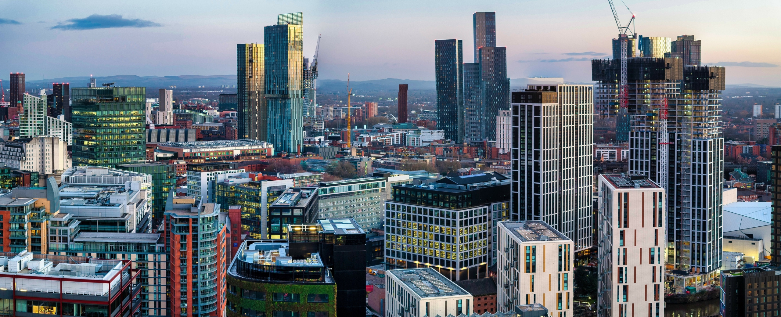 Aerial image of Manchester cityscape at dusk showing new urban developments