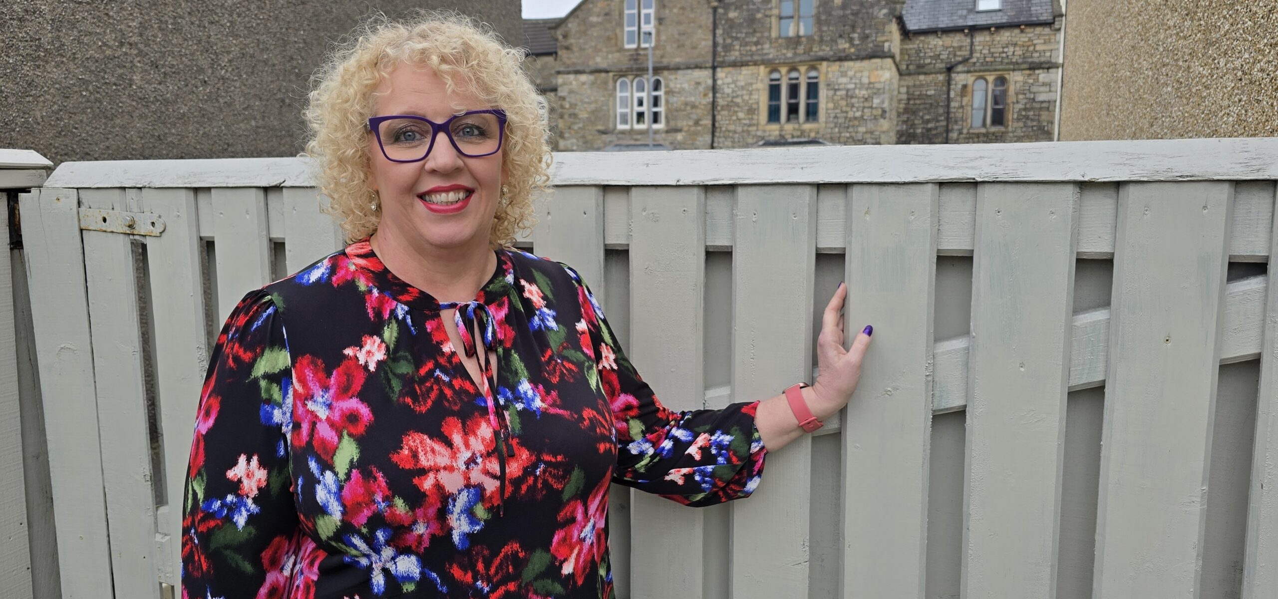 Karen Dickinson in front of a garden fence