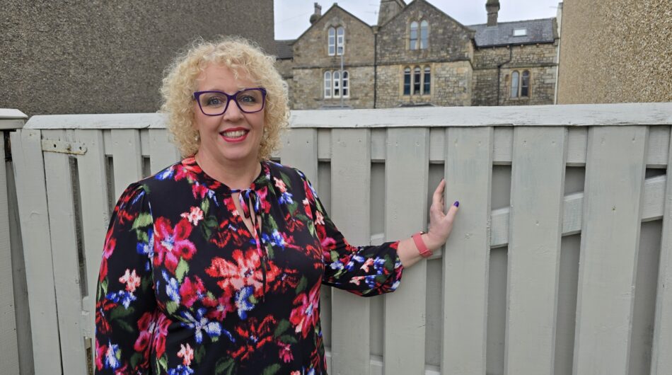 Karen Dickinson in front of a garden fence